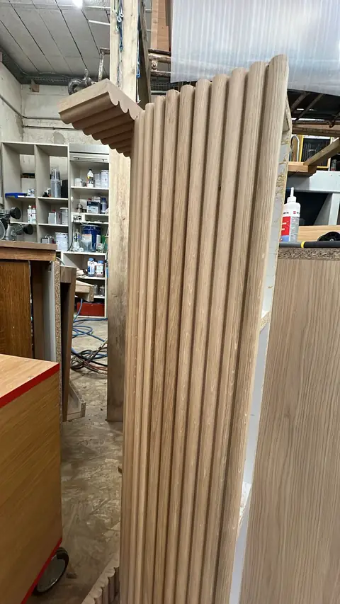 Colonne en bois habillée de cannelures, en cours d'assemblage.