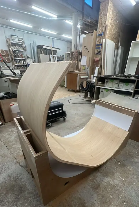 Panneau de bois cintré en cours de fabrication dans l'atelier.
