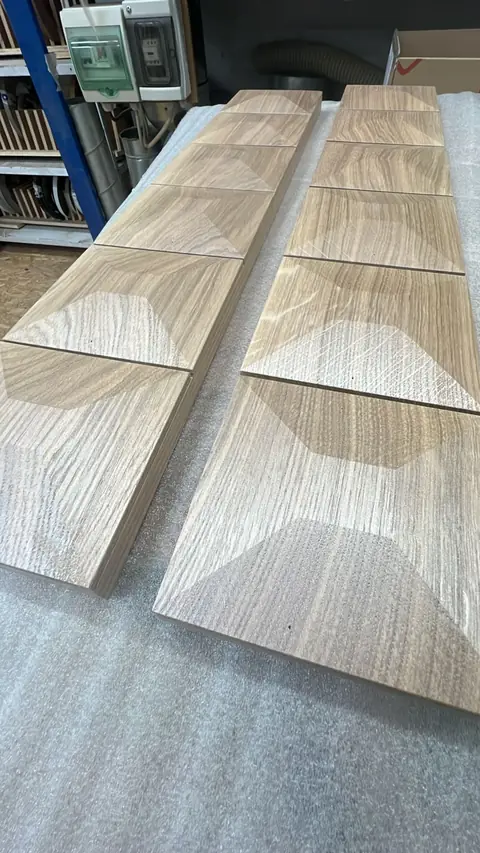Panneaux plaqués de bois clair aux veinures assemblées en motif.