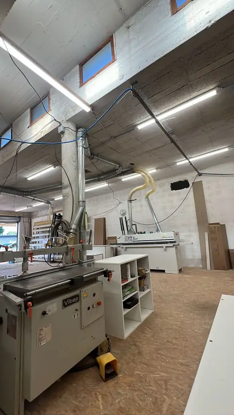 Vue de l'atelier de Carros avec ses machines à bois et ses aspirations.
