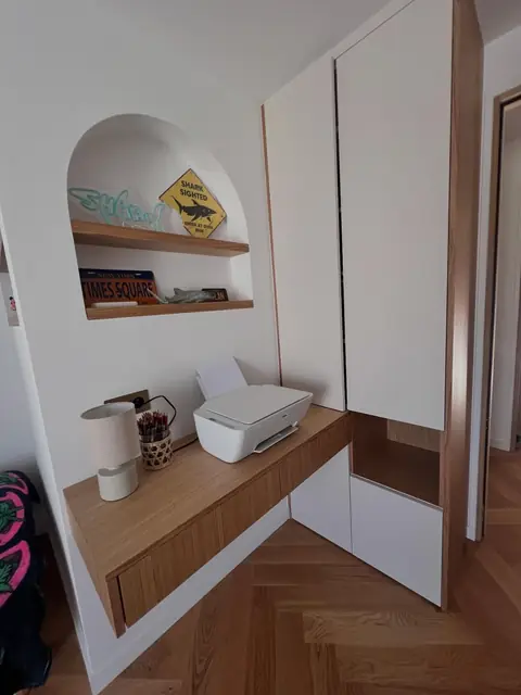 Bureau en chêne avec niche en arche, à côté d'un placard laqué blanc.