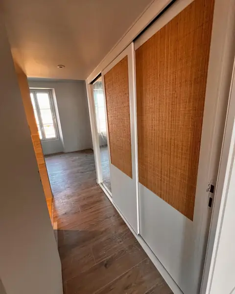 Portes de dressing en cannage le long d'un couloir.