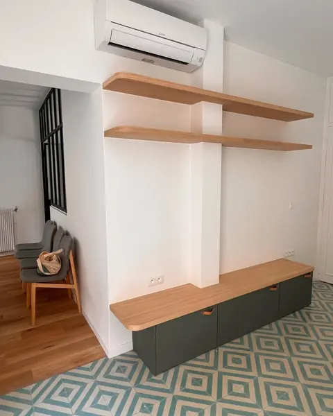 Meuble bas laqué vert avec plateau en chêne et étagères murales en chêne.