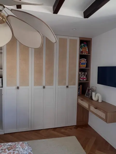 Placards de chambre sur mesure à portes blanches et panneaux cannés, avec étagères et bureau suspendu.