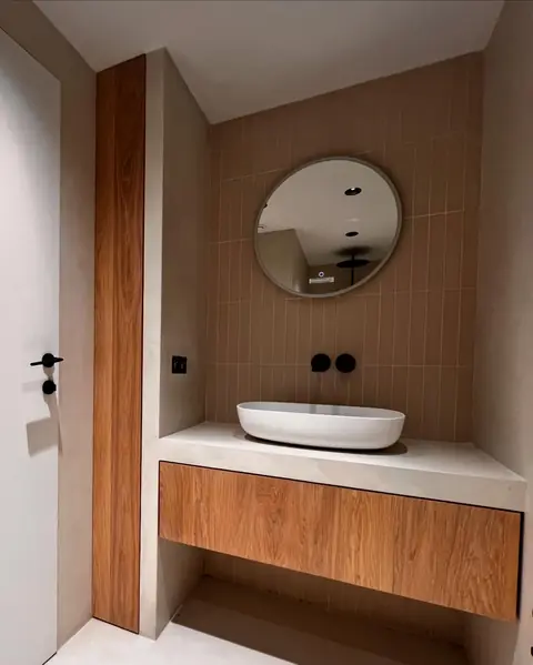 Meuble vasque en bois sous plan blanc, porte et montant en bois assortis.