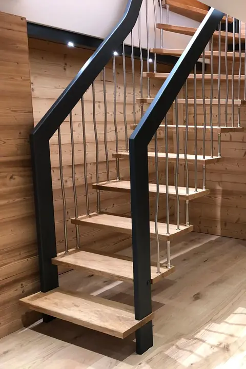 Escalier aux marches en bois et à la rampe en métal noir.