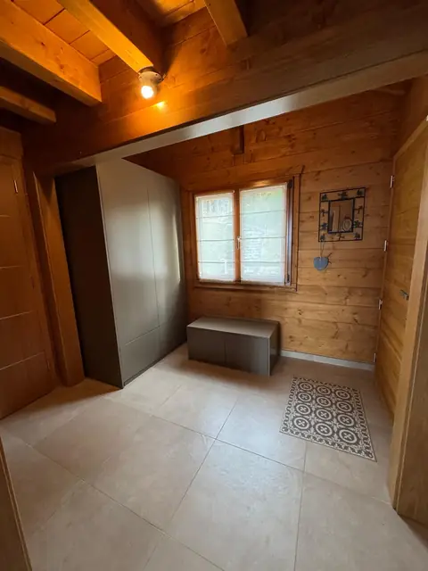 Entrée avec placard toute hauteur et banc coffre, murs en bois.