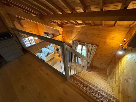 Mezzanine en bois avec garde-corps, vue plongeante sur le séjour.